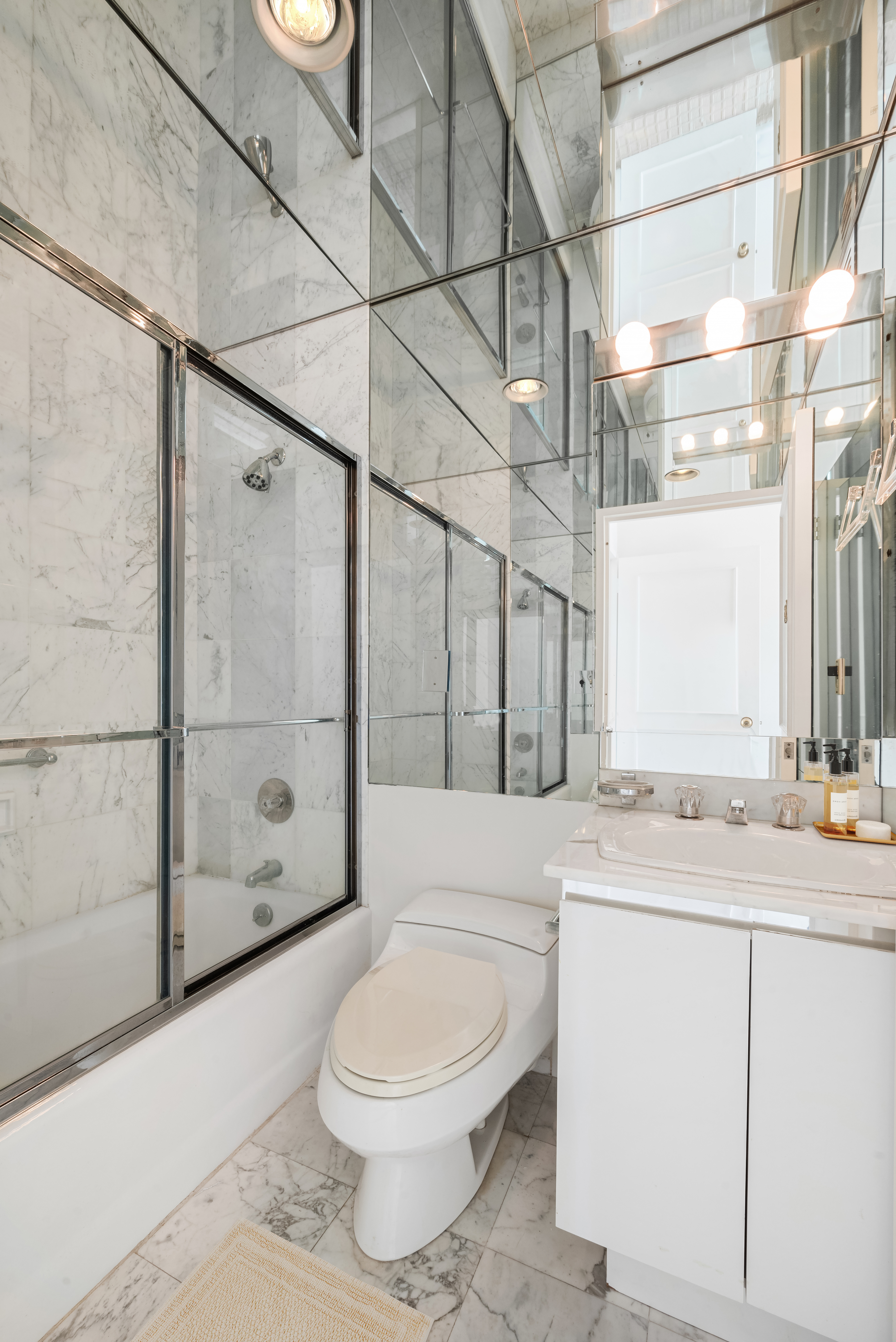 167 East 61st Street, Unit 29C Manhattan, NY 10065 - Photo 13 of 17 a bathroom with a sink a toilet and shower