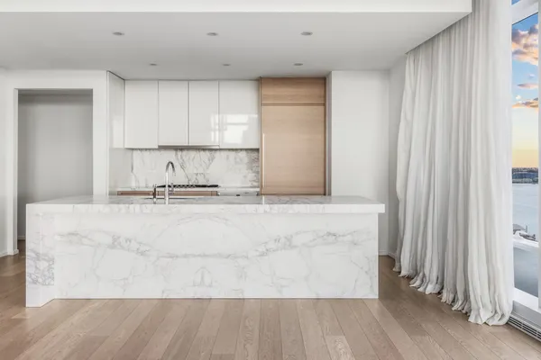 a kitchen with kitchen island sink and cabinets