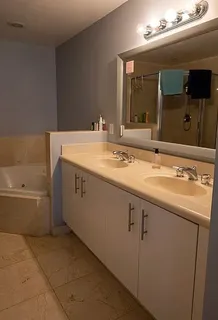 a bathroom with a tub sink and mirror
