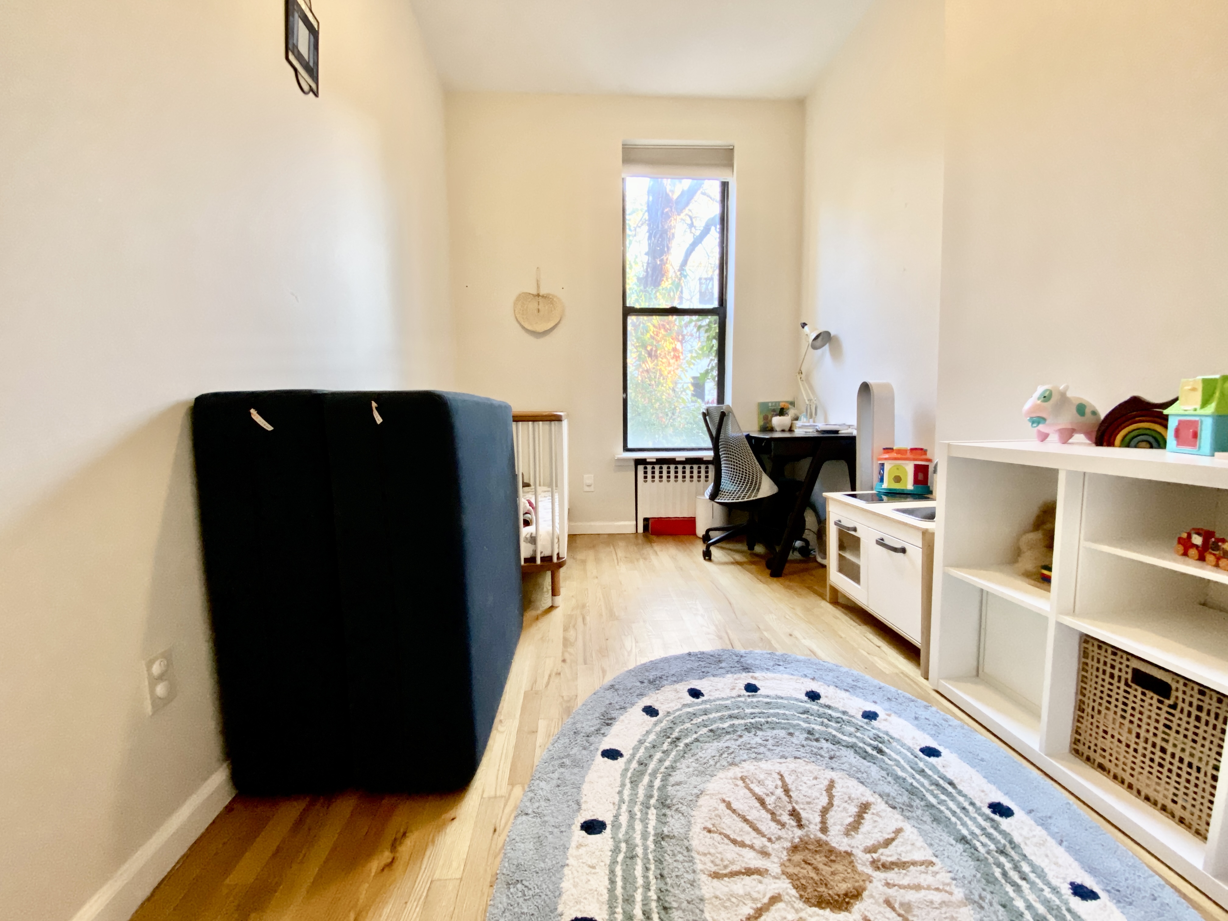 602 Madison Street, Unit 2 Brooklyn, NY 11221 - Photo 9 of 10 a living room with a bed and a large window
