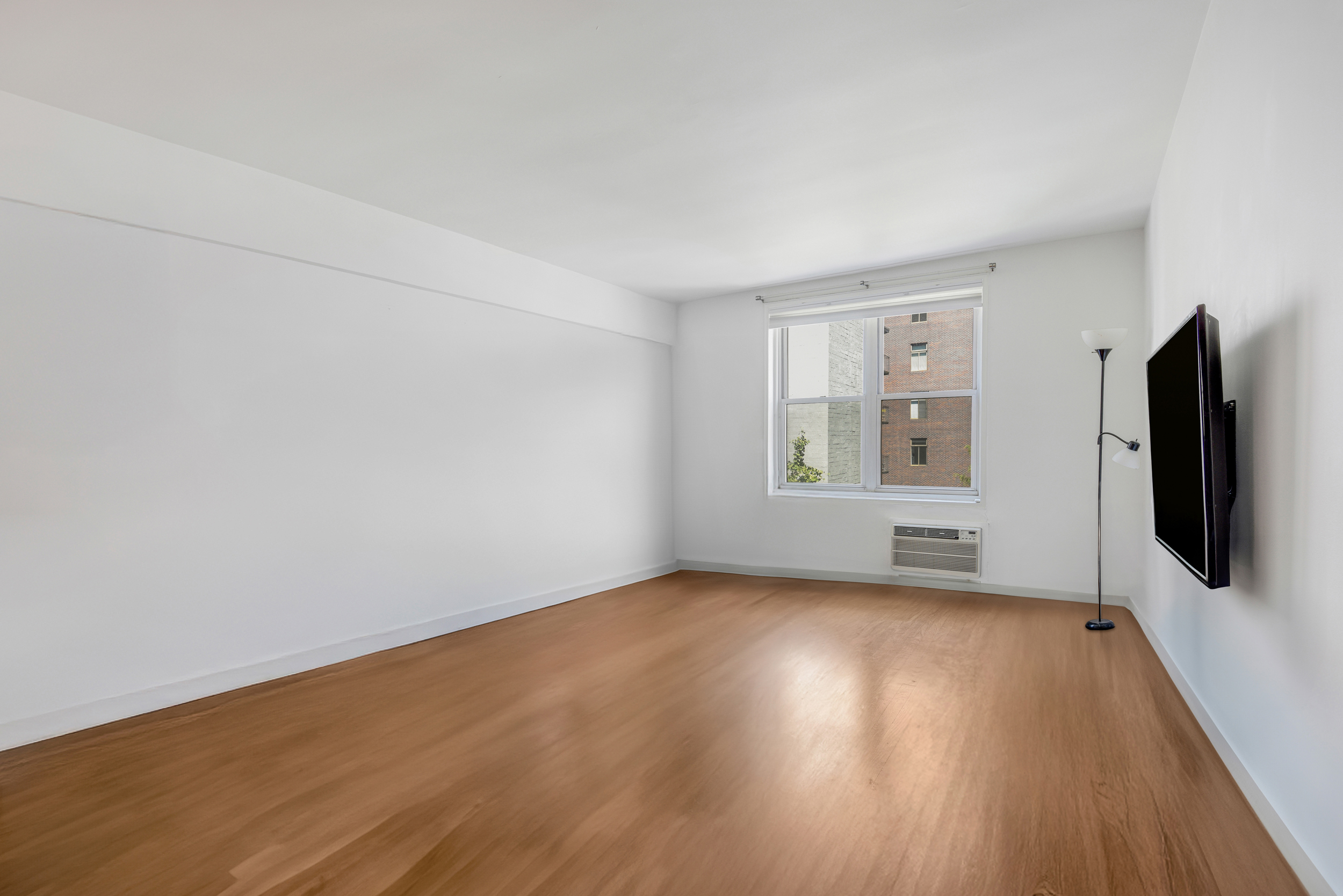 88 Bleecker Street, Unit 5J Manhattan, NY 10012 - Photo 8 of 18 wooden floor in an empty room with a window