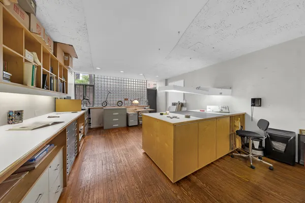 a kitchen with stainless steel appliances granite countertop a sink dishwasher a stove a dining table and chairs with wooden floor
