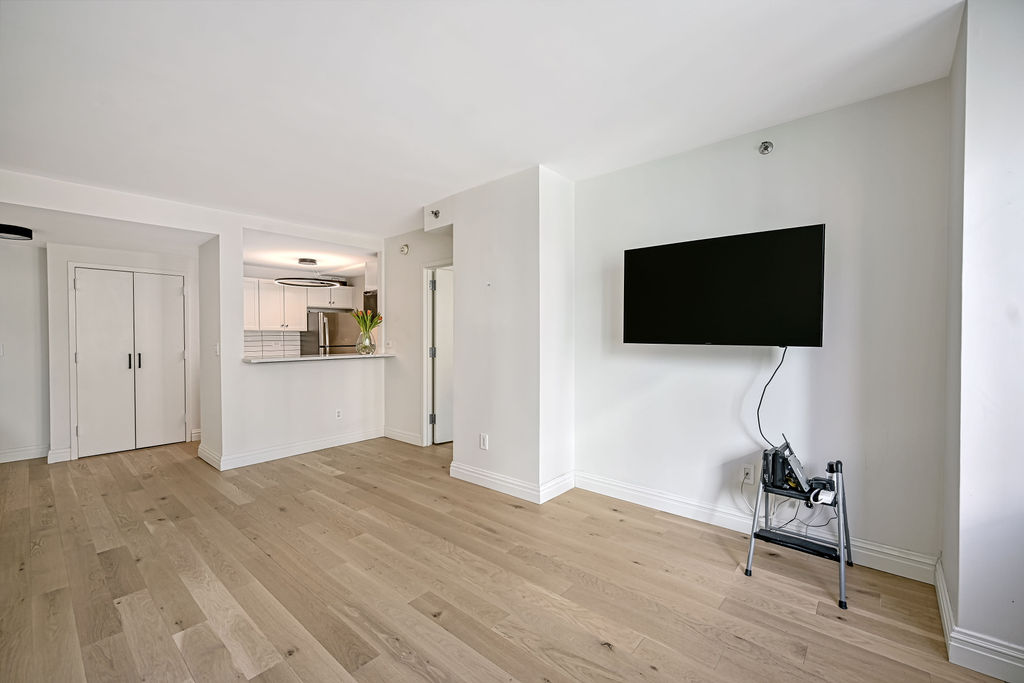 520 West 23rd Street, Unit 8C Manhattan, NY 10011 - Photo 8 of 10 a view of a livingroom with wooden floor and a flat screen tv