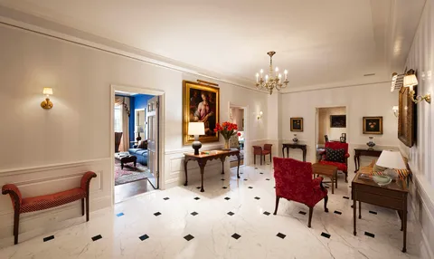 a living room with furniture a chandelier and a dining table
