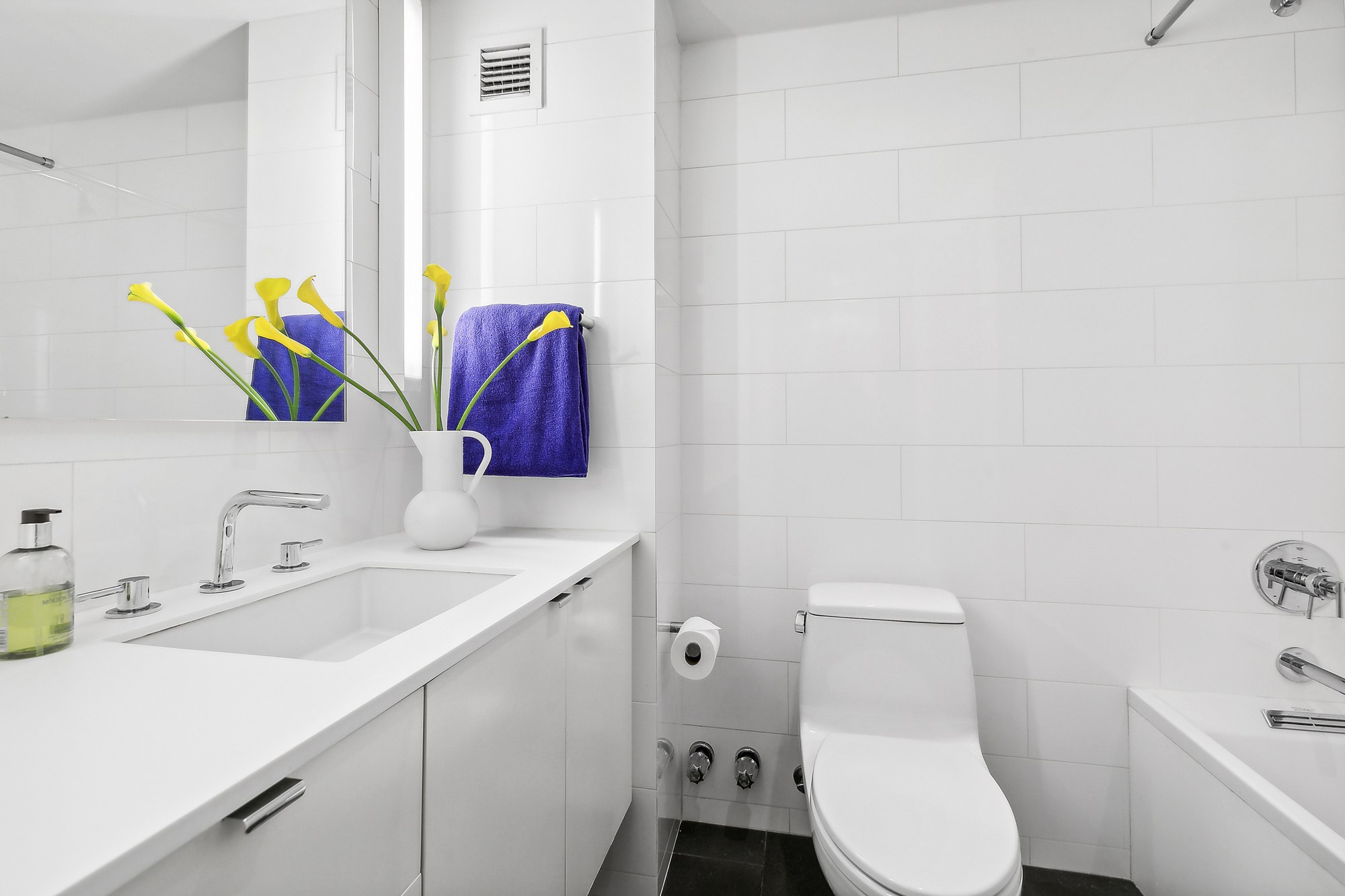 303 Greenwich Street, Unit 7F Manhattan, NY 10013 - Photo 6 of 7 a bathroom with a sink mirror vanity and toilet