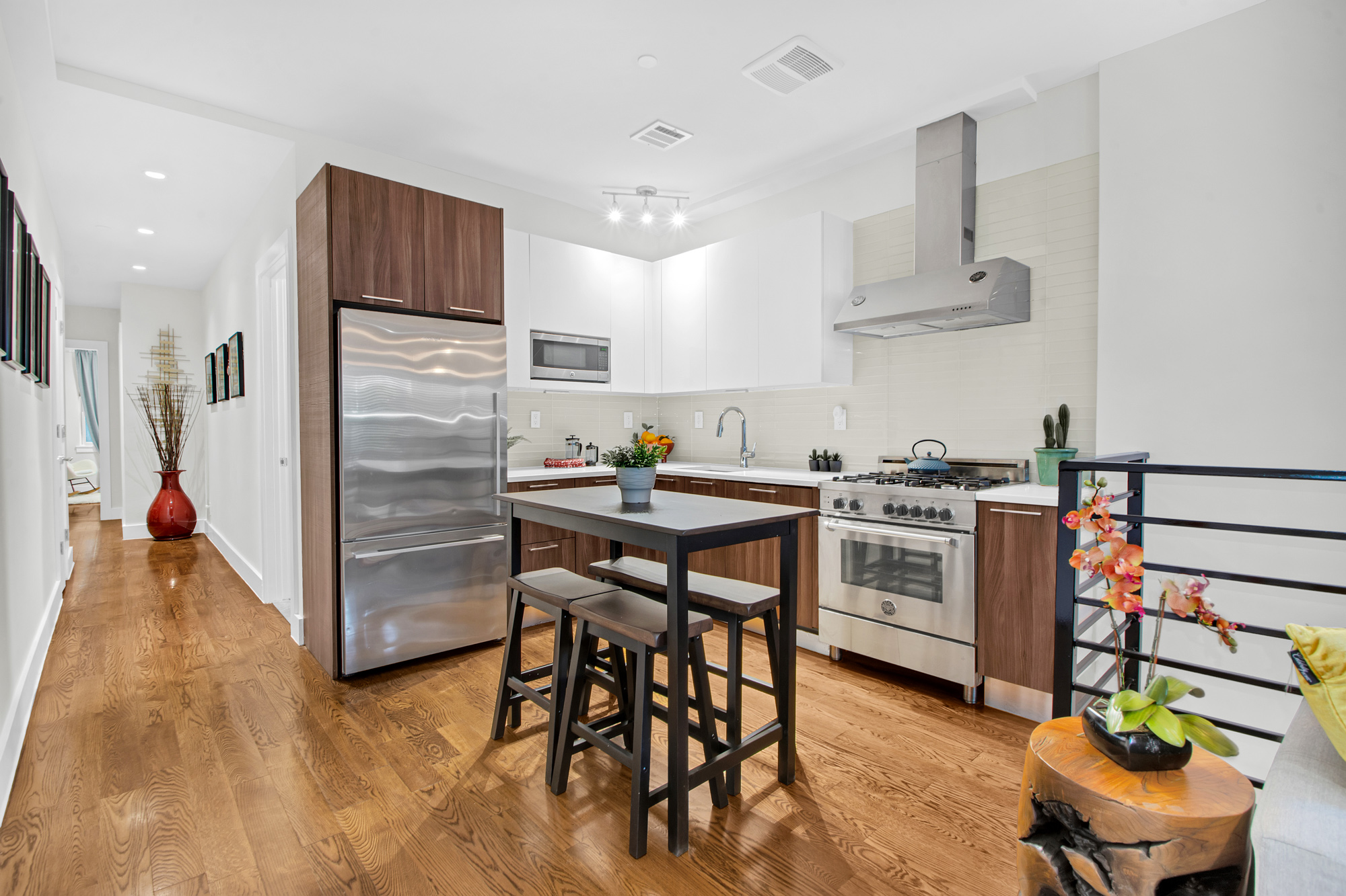 159 West 126th Street, Unit GARDEN A Manhattan, NY 10027 - Photo 5 of 15 a kitchen with stainless steel appliances kitchen island granite countertop a table chairs stove and white cabinets