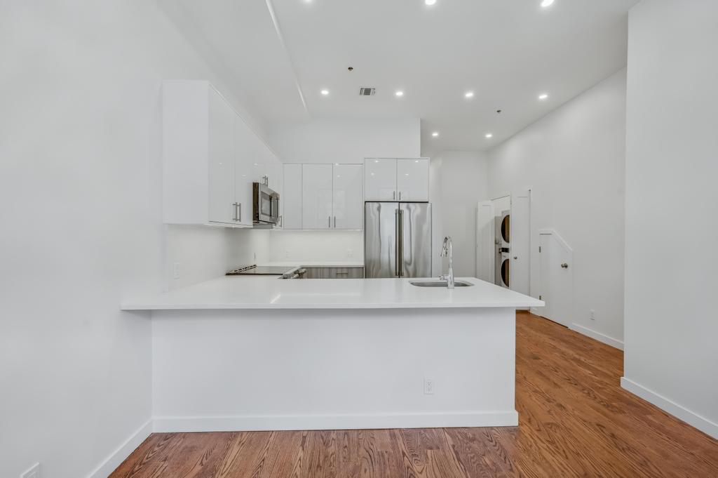 109 President Street, Unit 2 Brooklyn, NY 11231 - Photo 3 of 20 a large white kitchen with wooden floor