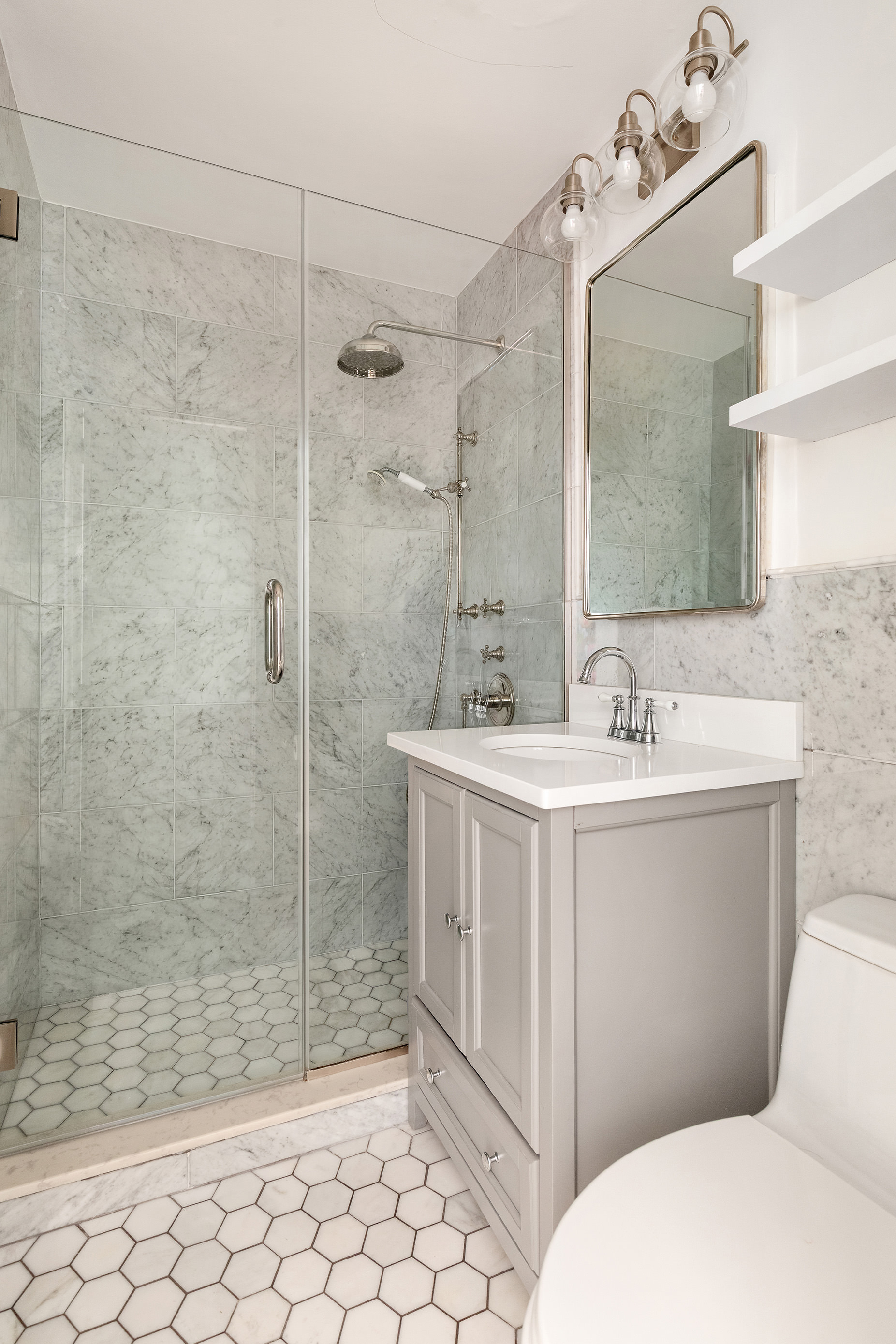 16 West 16th Street, Unit 12KN Manhattan, NY 10011 - Photo 6 of 8 a bathroom with a sink mirror vanity and toilet