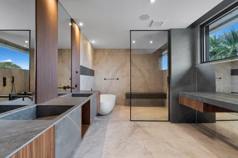 a spacious bathroom with a tub sink and mirror
