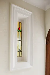 a view of a hallway with wooden floor and a bathroom