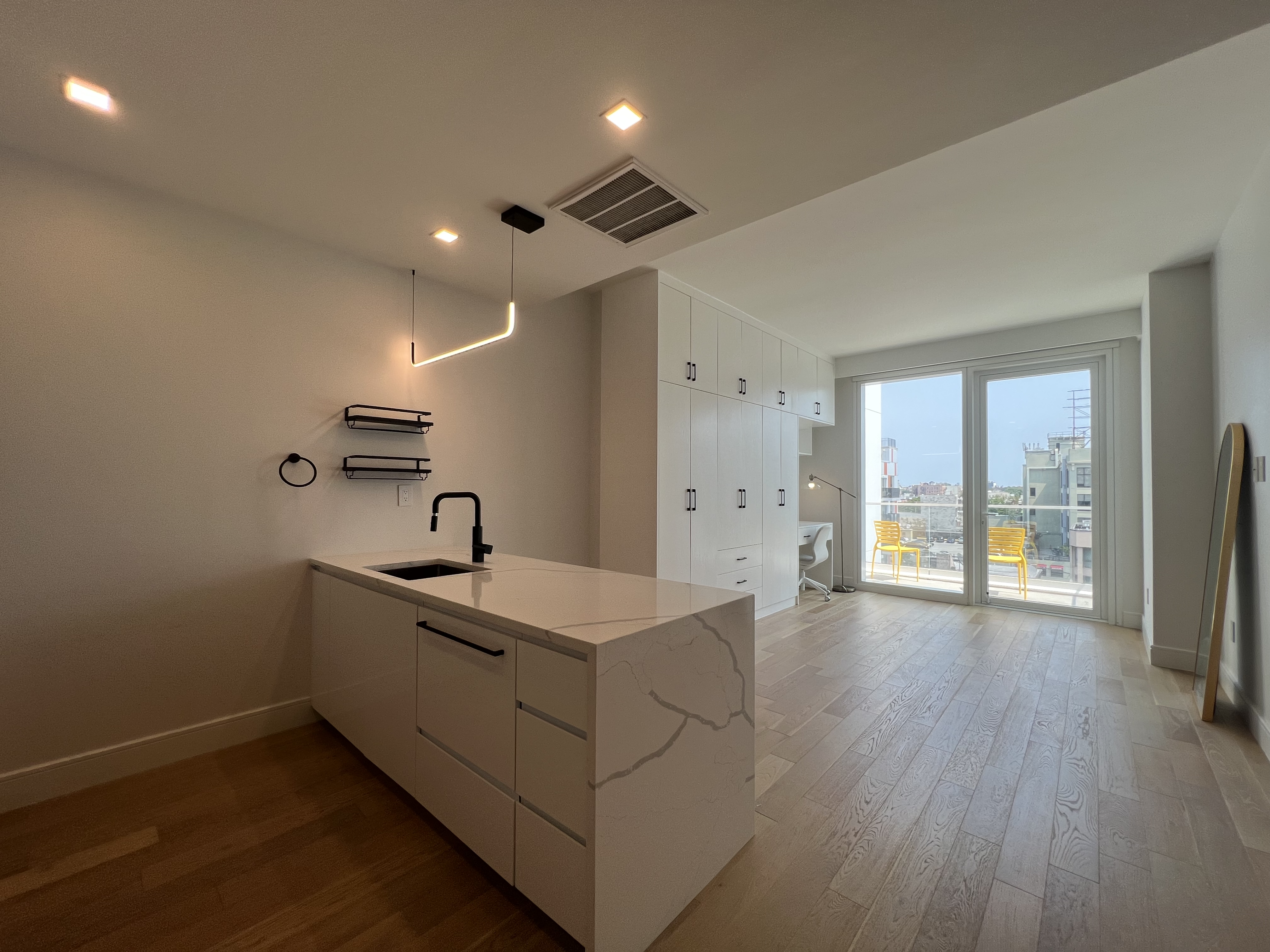 37-34 33rd Street, Unit 7H Queens, NY 11101 - Photo 1 of 18 a living room with stainless steel appliances kitchen island hardwood floor and a sink