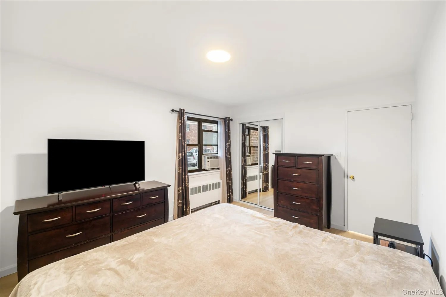 a bedroom with a bed and a flat screen tv