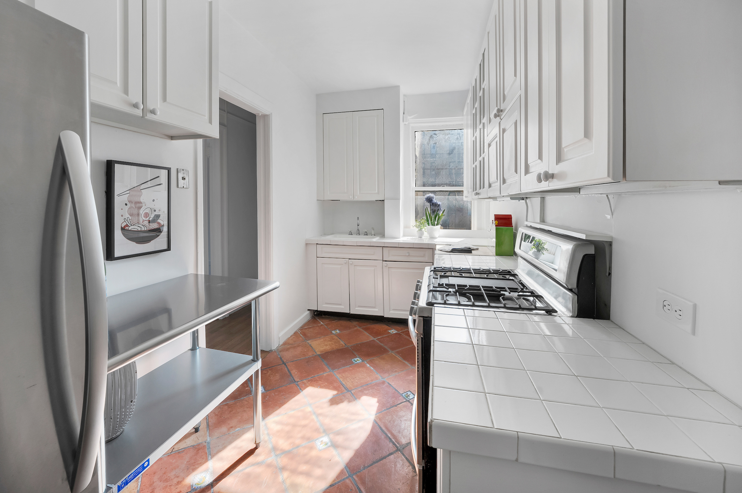 51 East 90th Street, Unit 8D Manhattan, NY 10128 - Photo 4 of 10 a kitchen with white cabinets and appliances