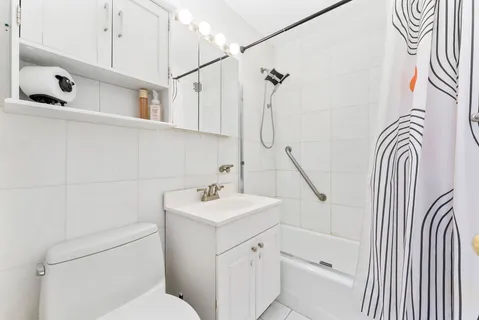 a bathroom with a sink a toilet and shower curtain