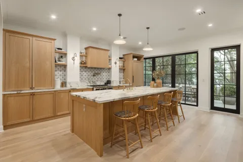 a kitchen with kitchen island granite countertop wooden cabinets and a refrigerator