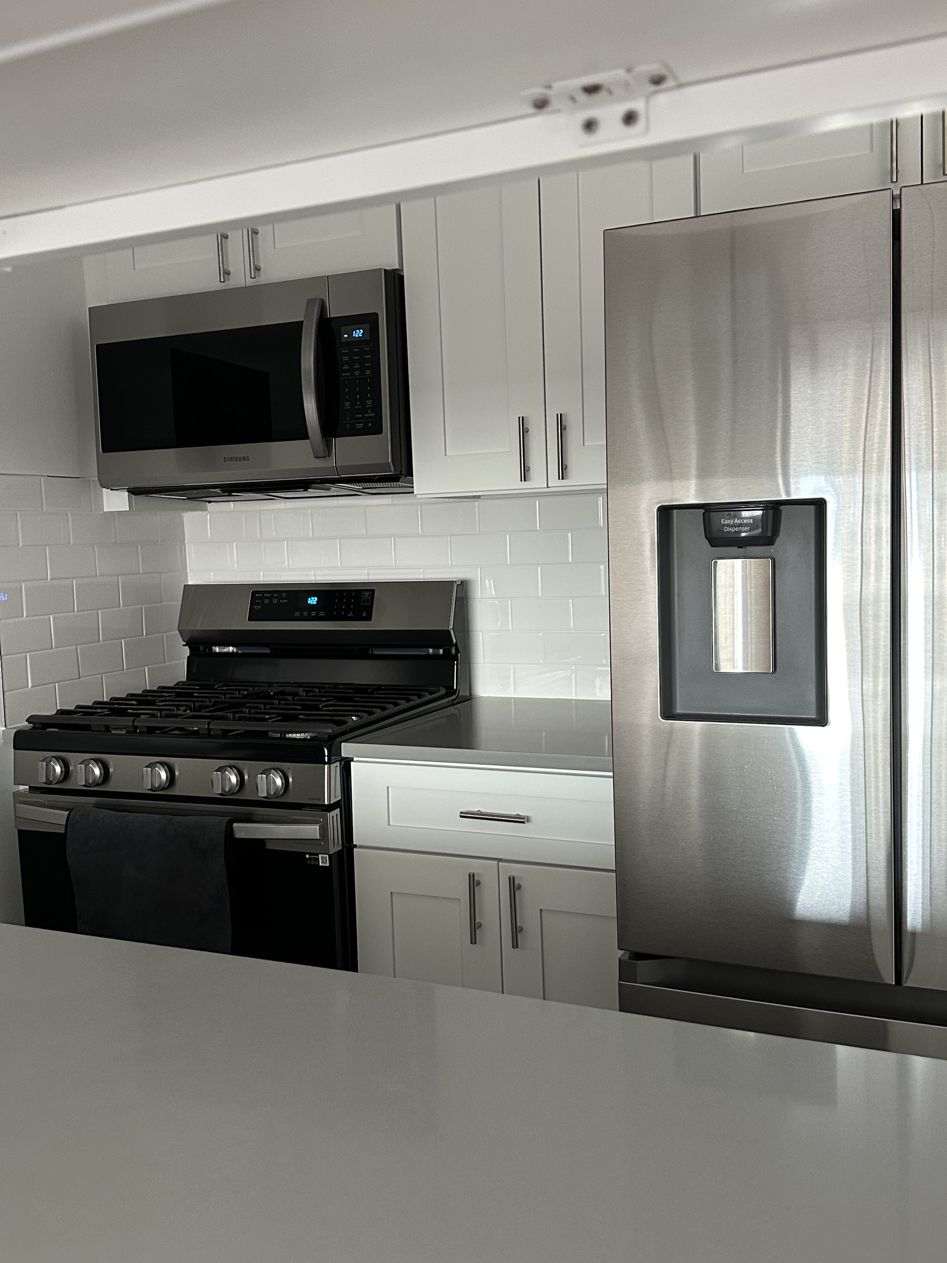 45 West 67th Street, Unit 21C Manhattan, NY 10023 - Photo 7 of 10 a kitchen with stainless steel appliances a stove a microwave and a refrigerator