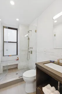 a bathroom with a sink a toilet and a window