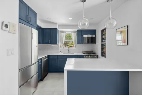 a kitchen with stainless steel appliances a stove refrigerator sink and microwave