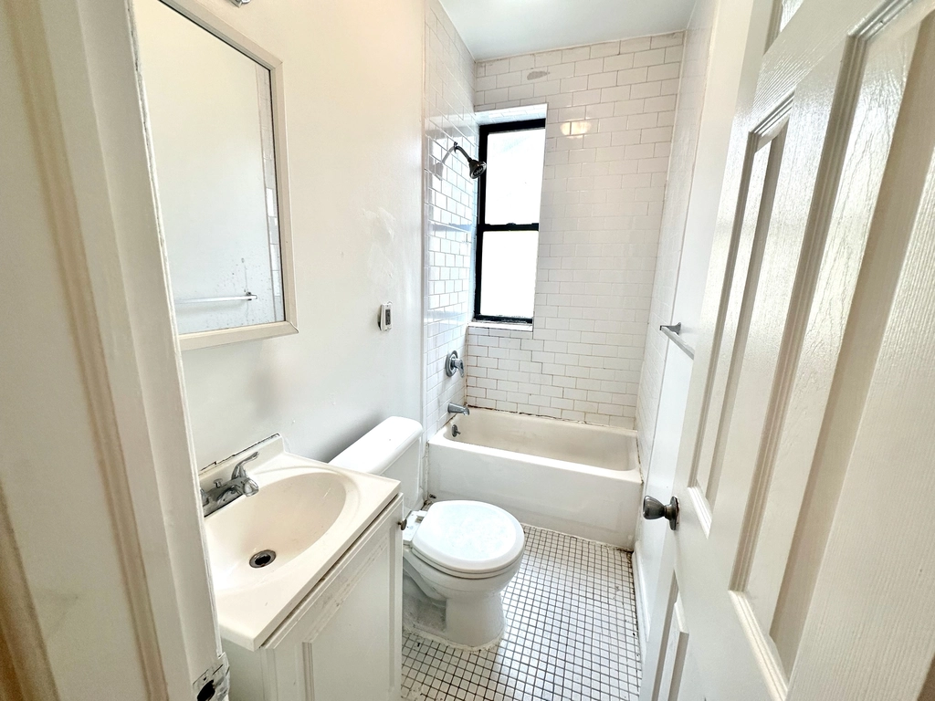 3694 Broadway, Unit 4F Manhattan, NY 10031 - Photo 4 of 4 a bathroom with a sink a toilet and a bathtub with shower