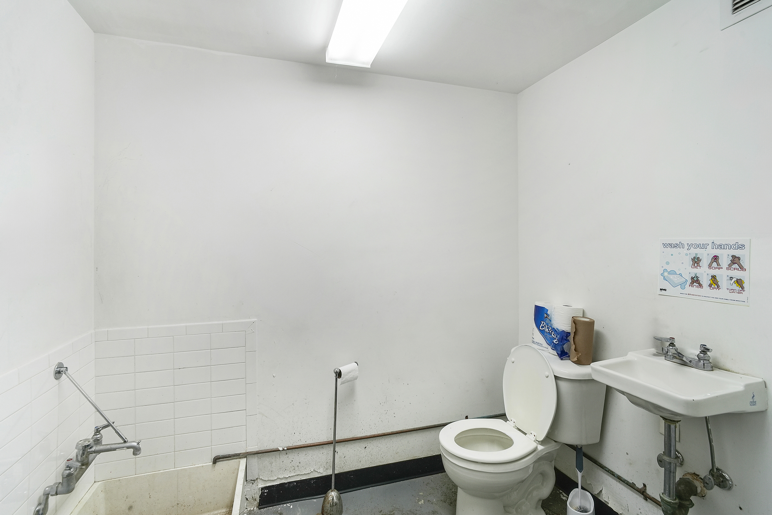 24 Beaver Street Manhattan, NY 10004 - Photo 9 of 25 a white toilet sitting next to a bathroom sink