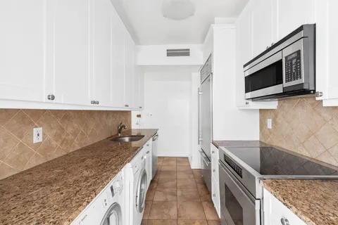 a kitchen with granite countertop a sink and stainless steel appliances