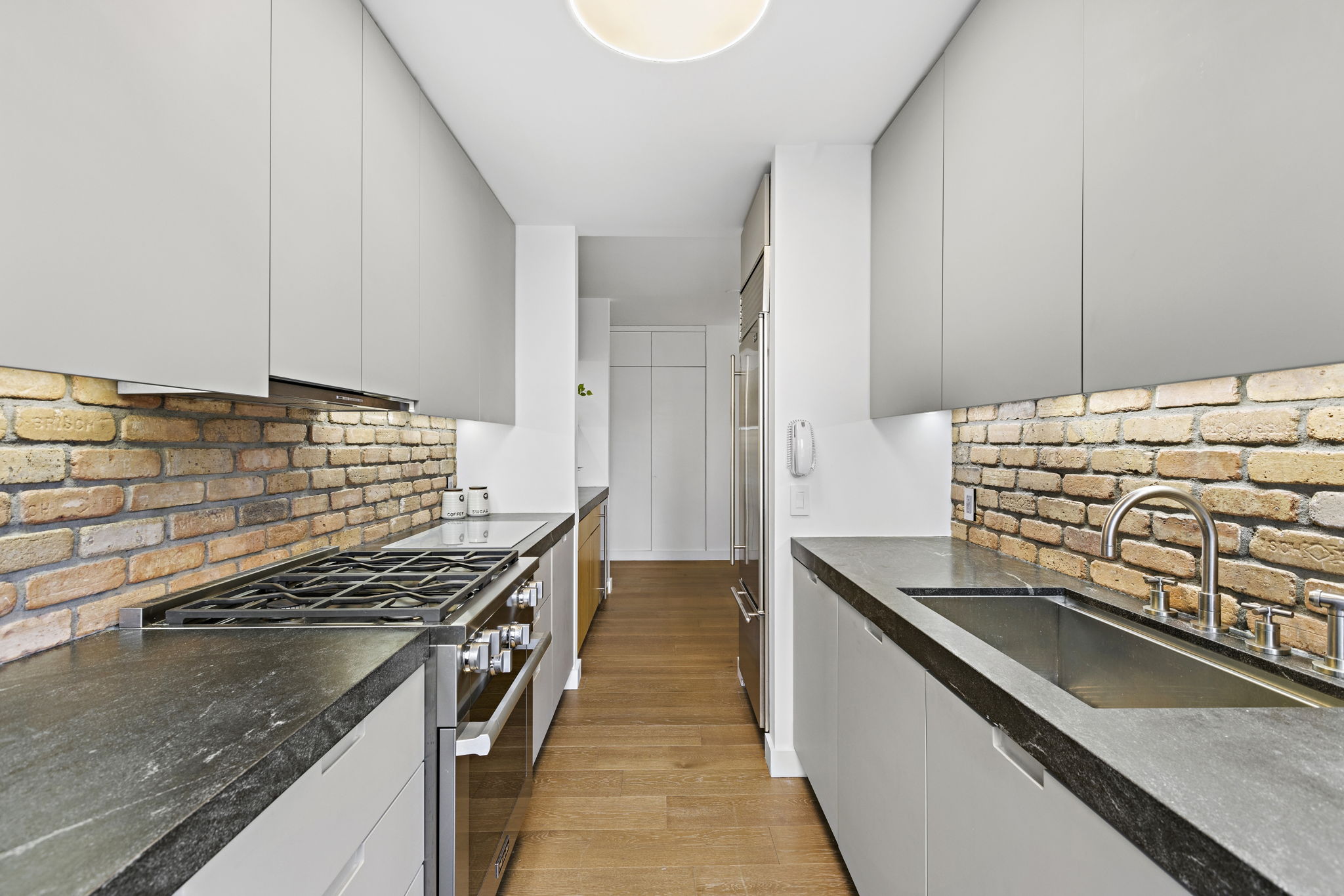 117 East 57th Street, Unit 21H Manhattan, NY 10022 - Photo 4 of 26 a kitchen with granite countertop a stove and a sink