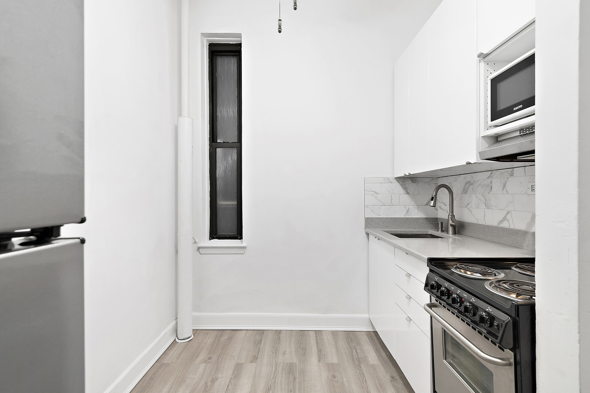 350 West 56th Street, Unit 1A Manhattan, NY 10019 - Photo 3 of 17 a kitchen with sink and cabinets