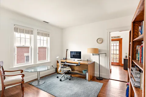 a view of a livingroom with workspace and a window