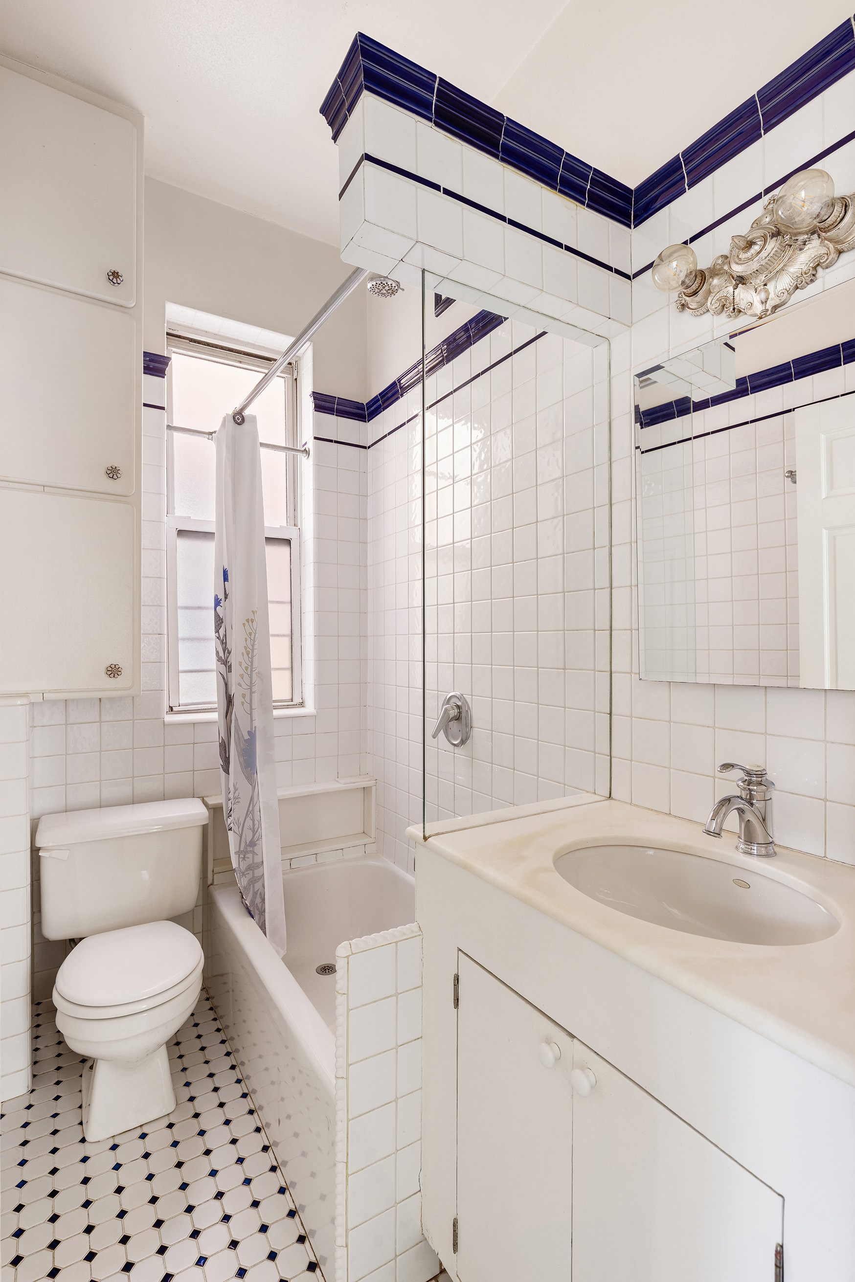 327 West 11th Street, Unit 5R Manhattan, NY 10014 - Photo 5 of 6 a bathroom with a sink toilet a mirror a bathtub and shower