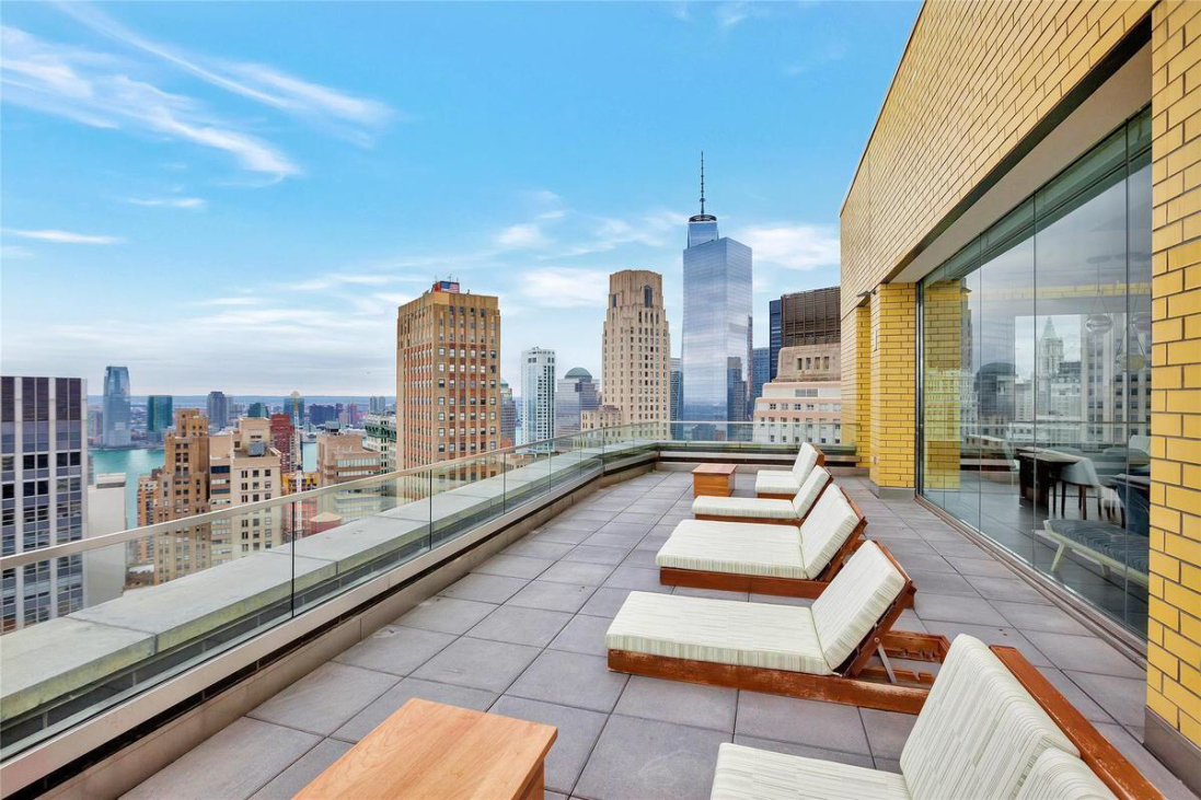 15 William Street, Unit 22H Manhattan, NY 10005 - Photo 14 of 20 a view of a city from a balcony with furniture