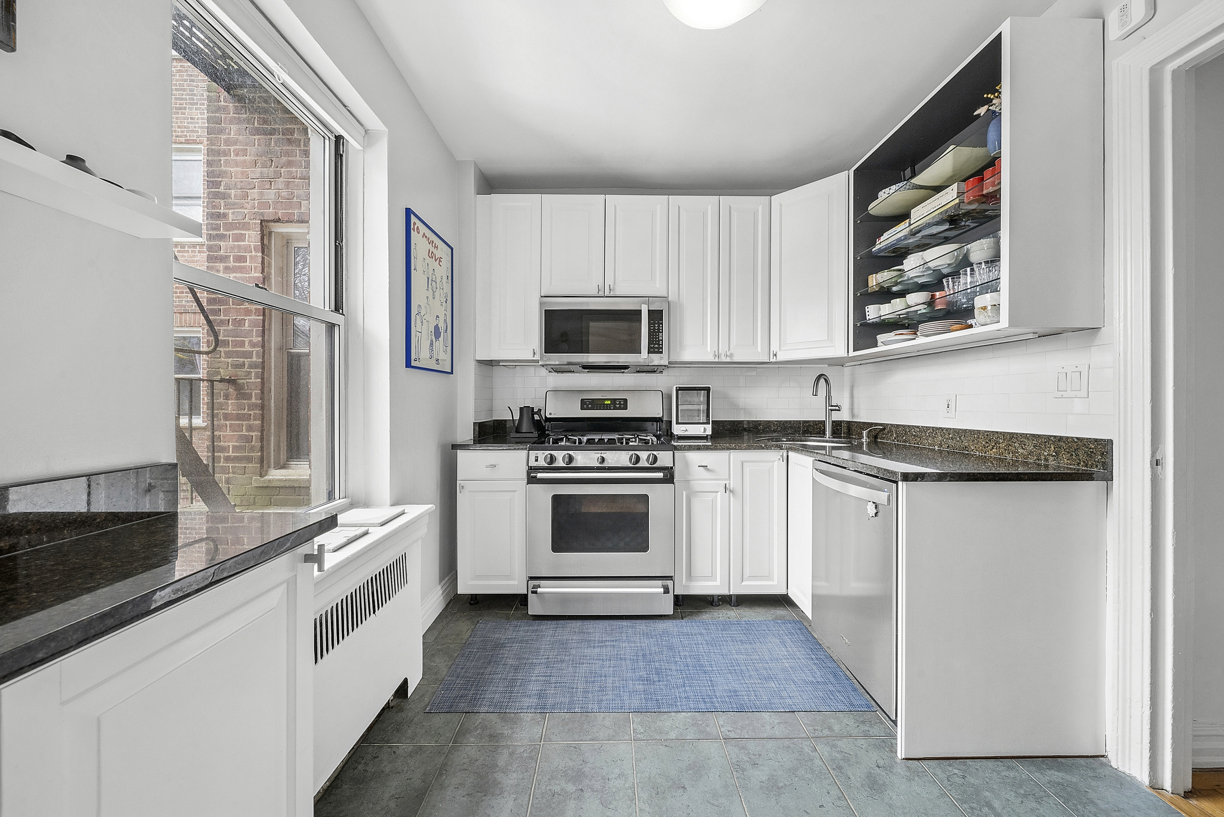 474 West 238th Street, Unit 2E Bronx, NY 10463 - Photo 5 of 13 a white kitchen with granite countertop a stove and a sink