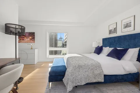 a spacious bedroom with a bed and glass window