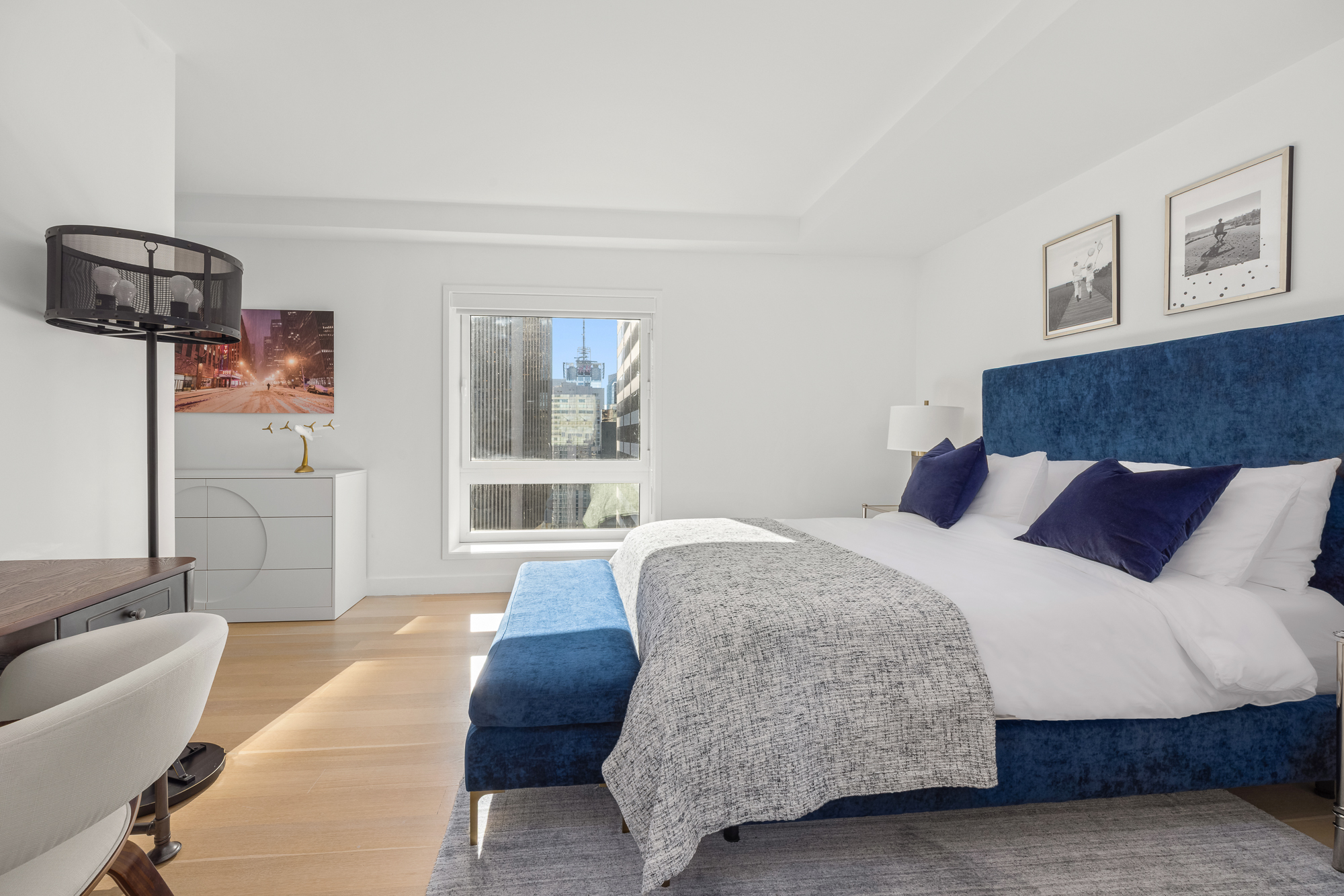 135 West 52nd Street, Unit 40A Manhattan, NY 10019 - Photo 19 of 24 a spacious bedroom with a bed and glass window