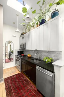 a kitchen with kitchen island granite countertop a sink a counter space and cabinets
