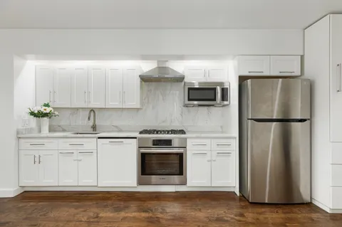 a kitchen with a stove refrigerator and microwave