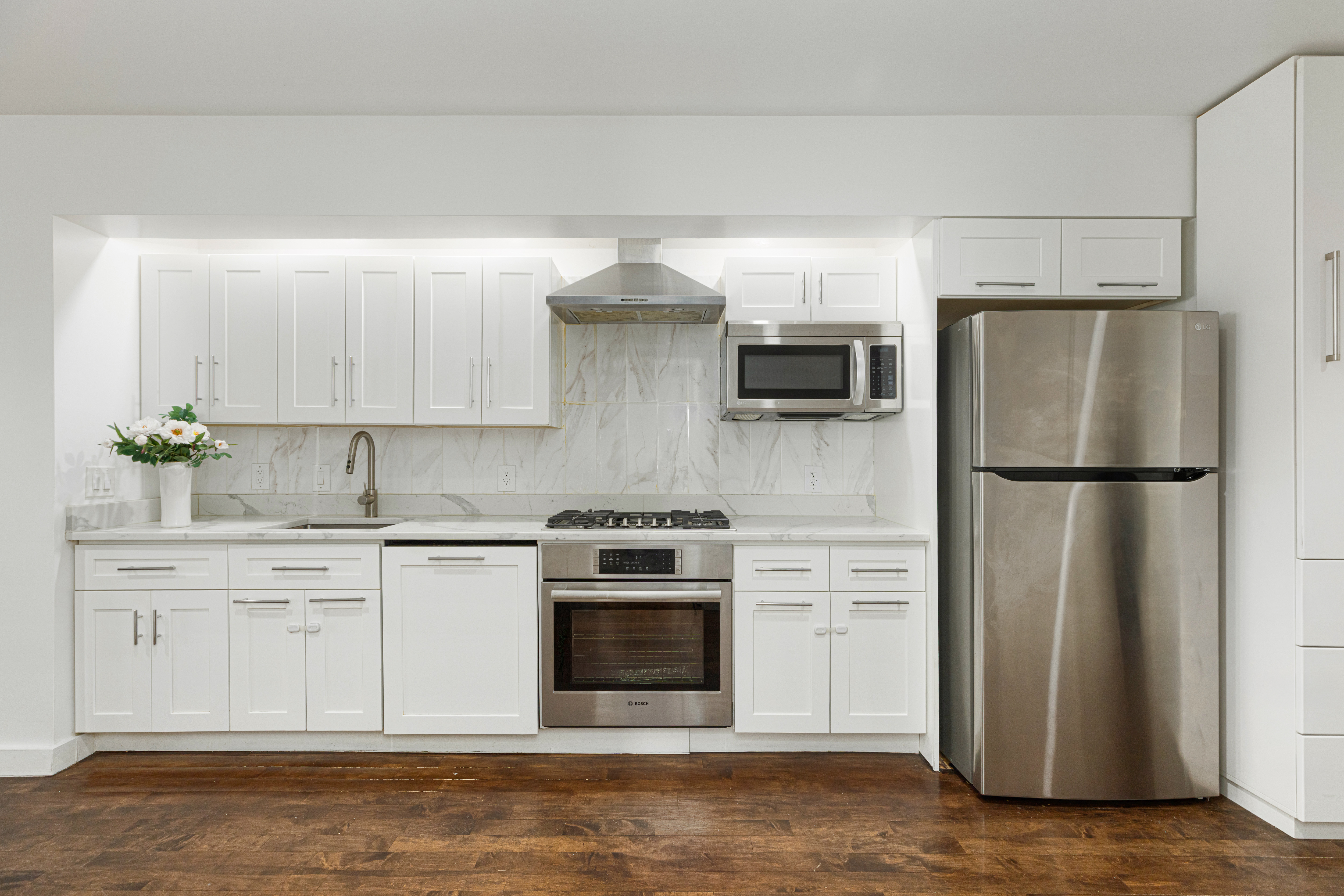 15 Broad Street, Unit 2300 Manhattan, NY 10005 - Photo 6 of 36 a kitchen with a stove refrigerator and microwave