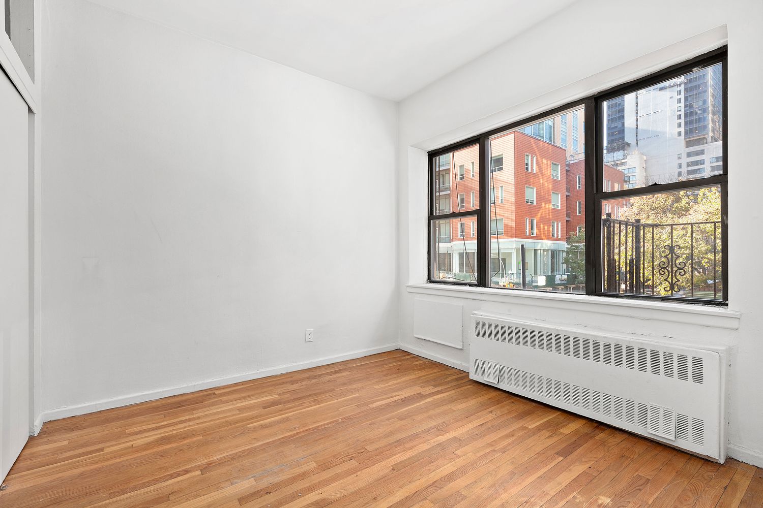 301 East 49th Street, Unit 3AB Manhattan, NY 10017 - Photo 3 of 7 a view of an empty room with wooden floor and a window