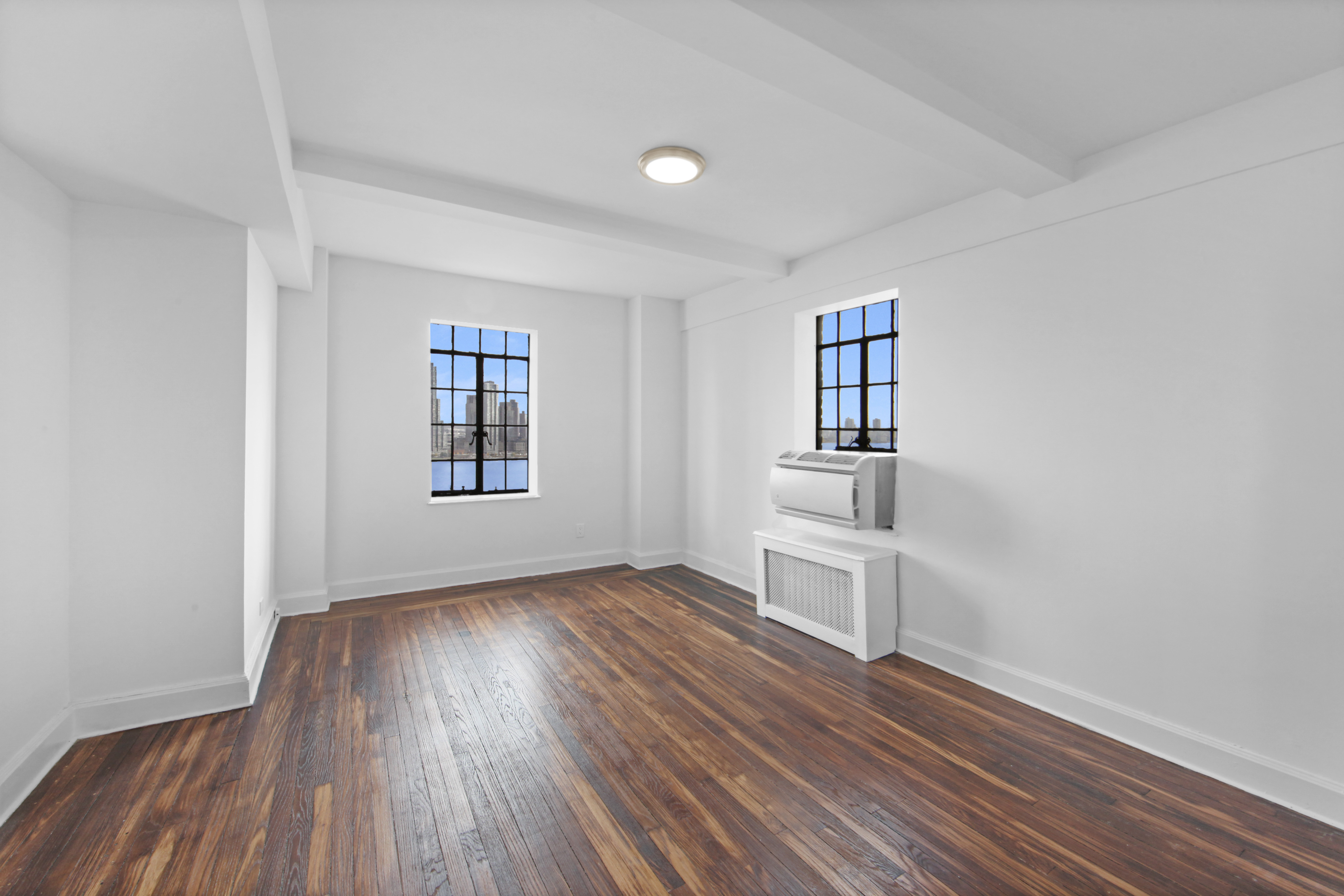 5 Tudor City Place, Unit 1536 Manhattan, NY 10017 - Photo 12 of 21 wooden floor in an empty room with a window
