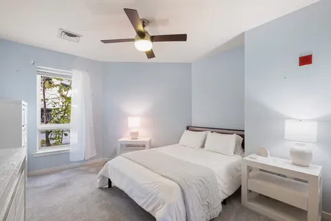 a bedroom with a bed and a large window