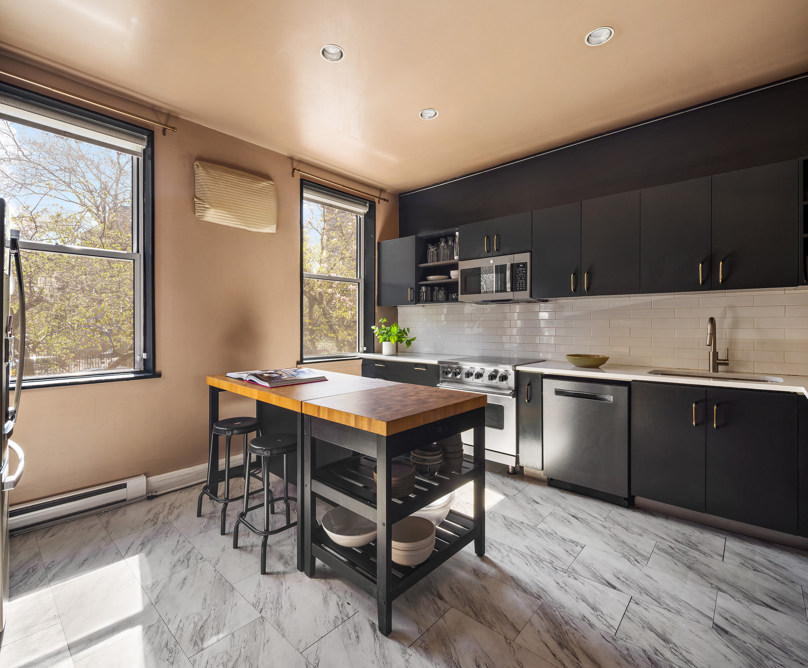 341 West 29th Street, Unit 1 Manhattan, NY 10001 - Photo 3 of 11 a kitchen with stainless steel appliances granite countertop a stove top oven a sink dishwasher a dining table and chairs with wooden floor