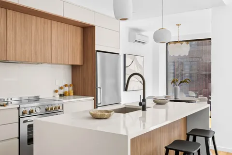 a kitchen with kitchen island a sink a stove and a refrigerator with wooden floor