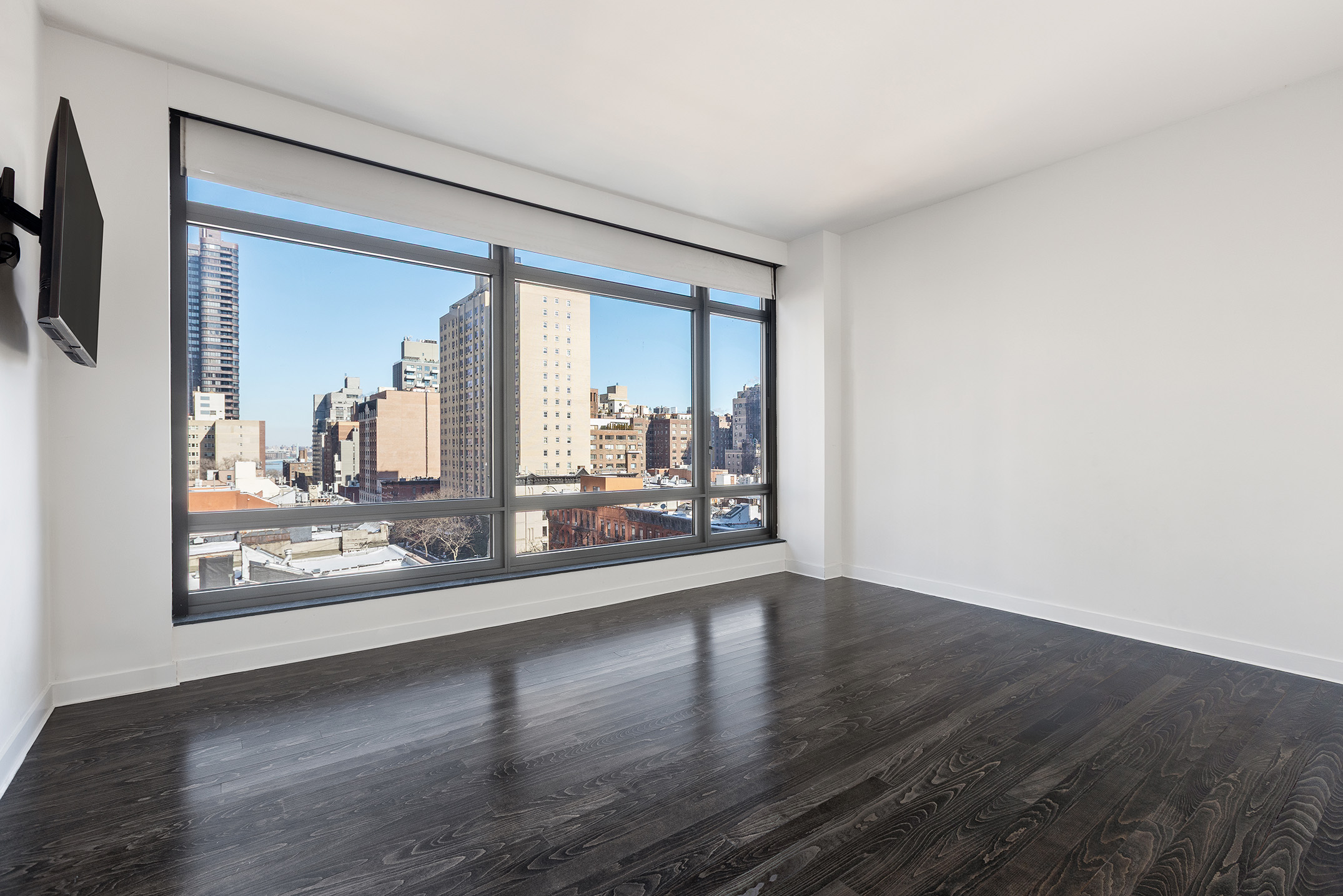 450 East 83rd Street, Unit 8B Manhattan, NY 10028 - Photo 8 of 22 a view of a room with wooden floor and a large window