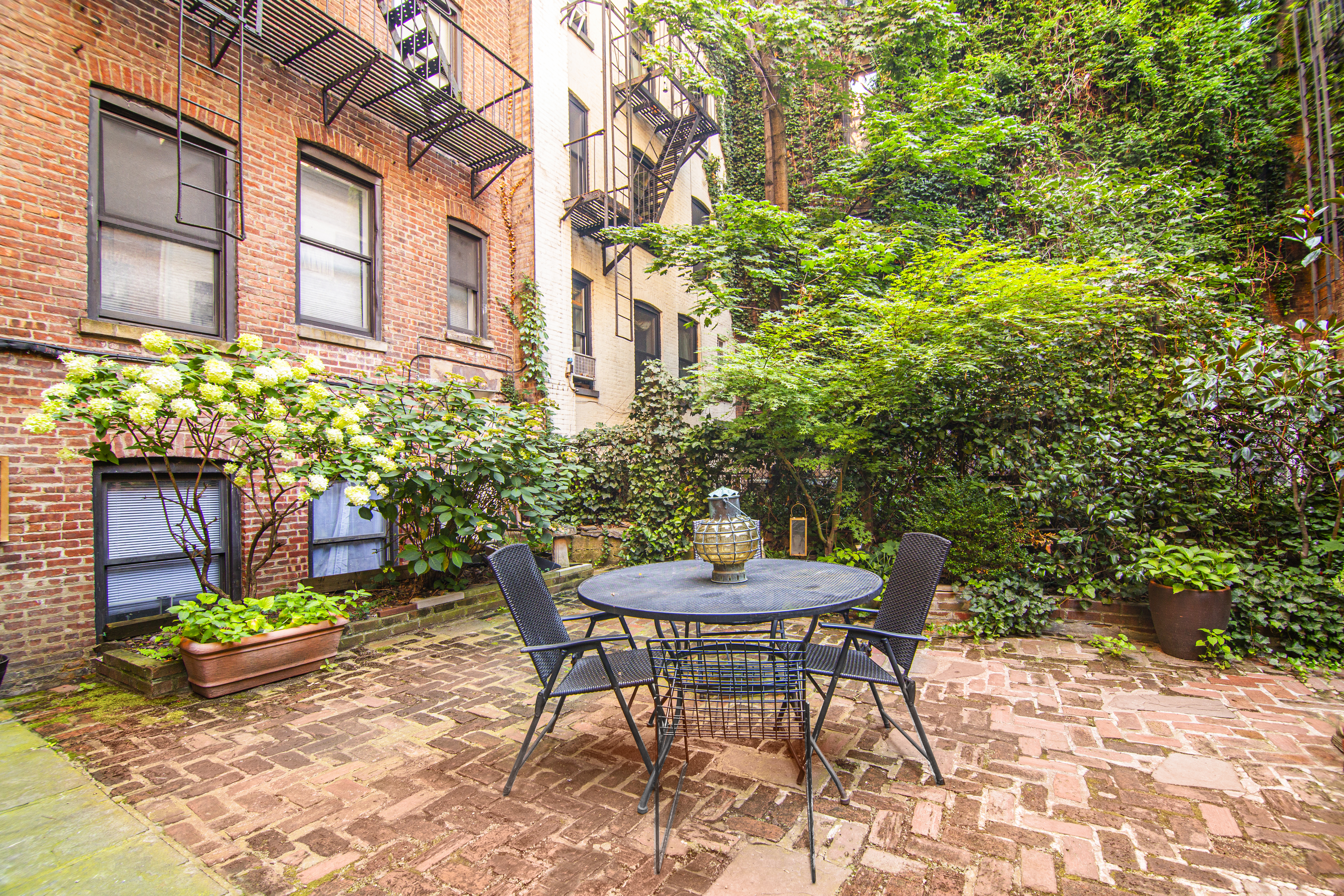 113 1/2 West 15th Street, Unit 1W Manhattan, NY 10011 - Photo 7 of 12 a view of a table and chairs in back yard of the house