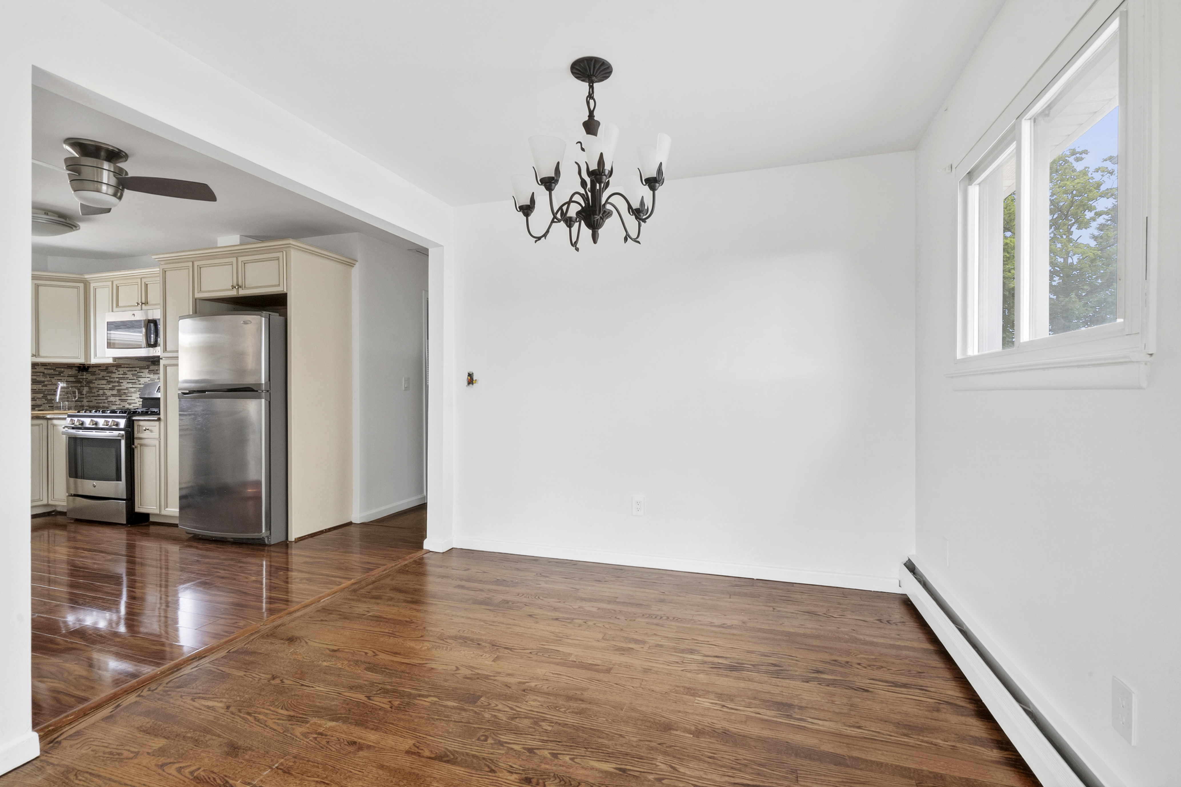 29 Athena Place Staten Island, NY 10314 - Photo 5 of 10 a view of a kitchen with wooden floor electronic appliances and window