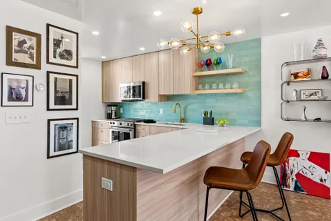 a kitchen with cabinets a center island and appliances