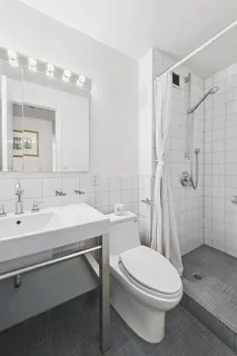 a bathroom with a sink a toilet and shower