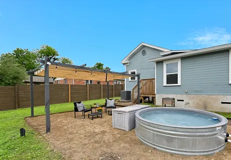 a backyard of a house with fountain table and chairs