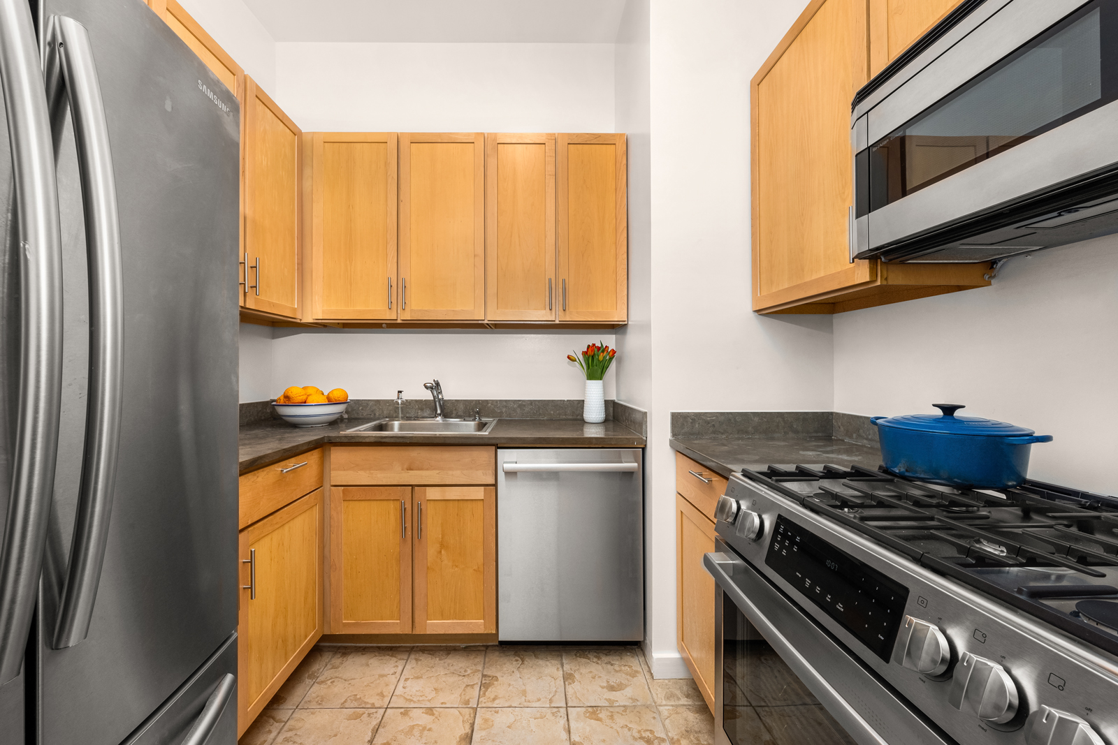 163 St Nicholas Avenue, Unit 1I Manhattan, NY 10026 - Photo 5 of 12 a kitchen with stainless steel appliances granite countertop a stove and a refrigerator