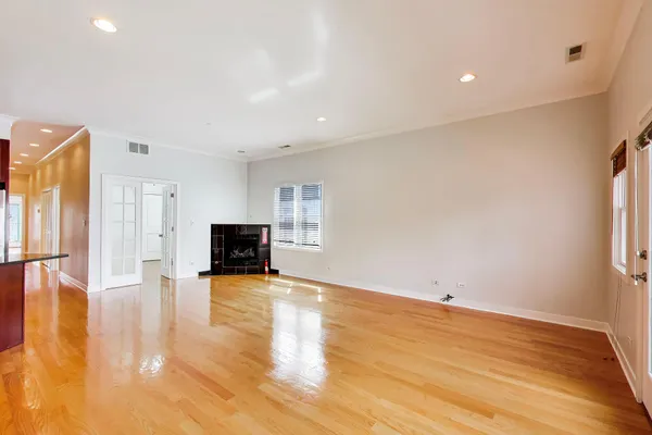 a view of empty room with wooden floor and fireplace