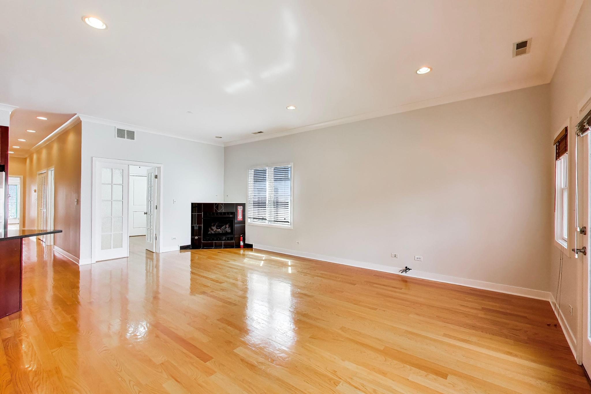 4845 North Springfield Avenue, Unit 2 Chicago, IL 60625 - Photo 4 of 32 a view of empty room with wooden floor and fireplace
